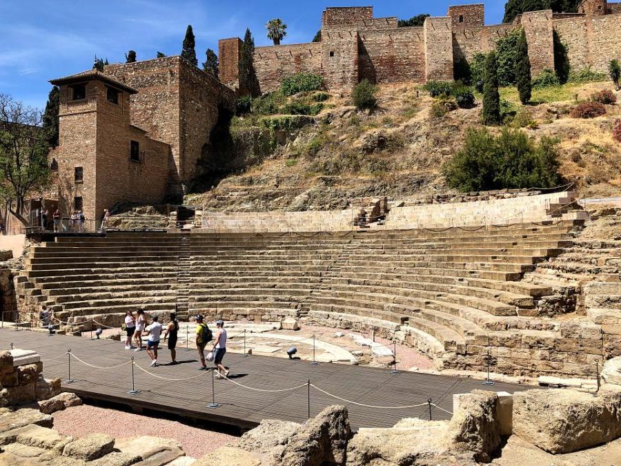 Students walking through a stone theatre